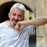 Mature man smiling looking at camera in urban background